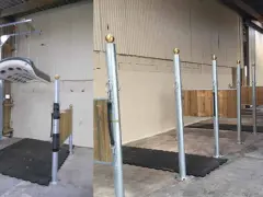 Aménagement d'une **dimension aire de pansage chevaux** avec tapis antidérapants et poteaux de contention. Un système de levage est visible.