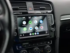 Ekran samochodu z widoczną aplikacją Android Auto, wyświetlającą ikony Kalendarz, Mapy, Spotify, WhatsApp i inne.