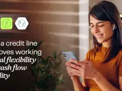 A woman smiles while looking at her phone, with icons representing financial flexibility and a working capital line of credit.