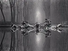 Rzeźby w stawie, koń i ludzie, odbijają się w wodzie. Styl Michael Kenna.