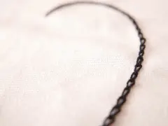 Un delicado corazón bordado con punto cadeneta sobre tela clara.
