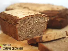 Chleb żytni z ziarnami, pokrojony na kromki, na drewnianej desce.
