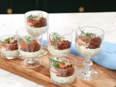 Små glas med silltårta kavring, krämig sås, rom, rädisa och dill. En festlig förrätt.