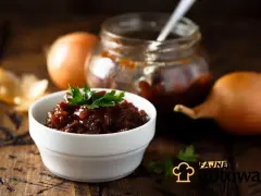 Cebulowy chutney w miseczce, obok cebuli i słoiczka. Pyszny dodatek do dań, który warto zrobić samemu.