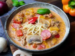 Herzhaftes pizzasuppe rezept mit Hackfleisch, Paprika, Mais und Pilzen, garniert mit Käse und Basilikum.