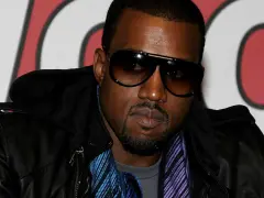 Kanye West w okularach przeciwsłonecznych i skórzanej kurtce, gotowy na koncert w Polsce.