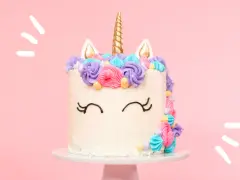 Magisk enhörningstårta med horn och öron, dekorerad med färgglad frosting. Ett perfekt unicorn tårta recept för kalaset!