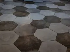 Nowoczesna podłoga bez fug, ułożona z sześciokątnych płytek w odcieniach szarości i grafitu.
