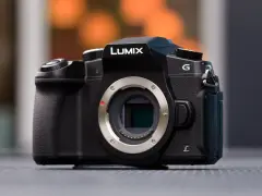 Czarny aparat Lumix G z widocznym mocowaniem obiektywu i migawką elektroniczną.