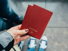 Dłoń trzyma paszport. Zastanawiasz się, ile kosztuje zmiana nazwiska? Czas na podróż i nowe życie!
