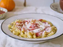 Fusilli z kremowym sosem i kawałkami owoców. Pyszny makaron na słodko, idealny na deser.