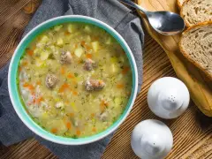 Aromaticzny zupa krupnik przepis babci, pełna ziemniaków, marchewki i mięsa, podana z chlebem.