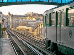 Un tren del metro de París, Francia, avanza por las vías al atardecer.