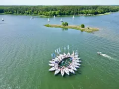 Flota jachtów tworzy okrąg na wodzie, tworząc niezwykły widok na Mazurach.
