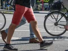 Ludzie idą i jadą na rowerze po mieście. Czy jazda na rowerze odchudza brzuch? Aktywność fizyczna pomaga spalać kalorie.