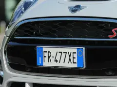 Targa di immatricolazione auto estera su una Mini Cooper S bianca.
