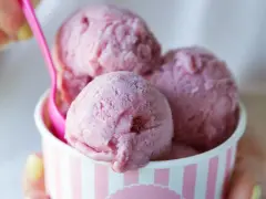 Różowe lody w kubeczku, z różową łyżeczką. Zastanawiasz się, ile kalorii mają lody?