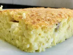 Una fetta di timballo di riso dorato e filante, con un ripieno cremoso e invitante.