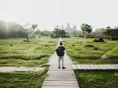 Chłopiec z plecakiem idzie ścieżką do Angkor Wat, jednego z cudów największego kontynentu na ziemi.