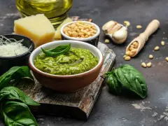 Un tazón de pesto genovés fresco con albahaca, piñones, ajo, queso parmesano y aceite de oliva.