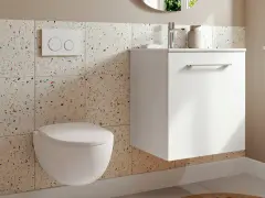 Une petite toilette moderne suspendue, avec un mur en carreaux de terrazzo colorés et un meuble blanc flottant.