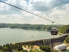 Kolejka gondolowa nad zaporą w Solinie, z widokiem na jezioro i zalesione wzgórza.