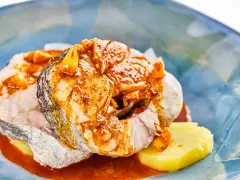 Merluza a la gallega con patatas y salsa de pimentón, un plato tradicional gallego lleno de sabor.