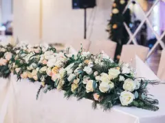 Eleganckie kwiaty na wesele zdobią stół, tworząc romantyczną atmosferę. Bukiet z róż i zieleni.