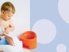 Małe dziecko siedzi na niebieskim nocniku, bawiąc się papierem toaletowym. Kiedy uczyć dziecko na nocnik? Czas zacząć!