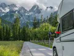 Kamper na tle górskich krajobrazów. Wygodna podróż po gotowych trasach kamperowych.