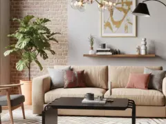 Przytulny salon z kanapą w kolorze słomkowym, szarymi fotelami, ceglaną ścianą i dużą rośliną.