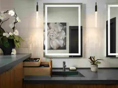 Elegante tocador con espejo iluminado, lavabo empotrado y orquídeas. Ideal para calcular el precio reforma baño 4 m2.