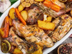 Pieczony królik z ziemniakami, marchewką i czosnkiem, doprawiony ziołami. Idealna marynata do królika pieczonego w piekarniku.