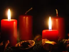 Two red candles glow, marking the 2nd advent. A festive wreath with dried orange slices and pine needles surrounds them.