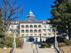 Piękny budynek sanatorium w Jesenikach w Czechach, z charakterystycznymi arkadami i żółtymi balkonami.