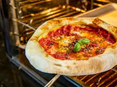 Frisch gebackene Pizza Margherita ohne Backpapier auf einem Ofenrost, mit geschmolzenem Käse und frischem Basilikum.