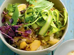 Eine bunte Spargel Bowl mit Reis, Ei, Sprossen und frischen Kräutern, appetitlich angerichtet.