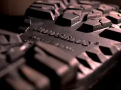Detalle de la suela de caucho de una bota, con un patrón de tacos pronunciados. La inscripción "SLIP RESISTANT" confirma que la suela de caucho no resbala.