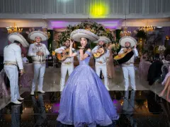 Dziewczyna w fioletowej sukni i mariachi śpiewają. W tle weselne dekoracje, jakby to były wiejskie przyśpiewki weselne tekst.