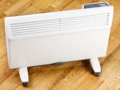 Biały, nowoczesny grzejnik elektryczny na kółkach, idealny do ogrzewania domu. Sprawdź nasz energooszczędne grzejniki elektryczne ranking!