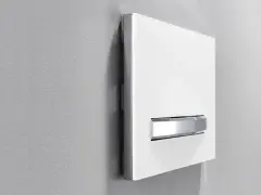 Plaque de déclenchement blanche avec double poussoir chromé pour une chasse d'eau à double débit, optimisant la consommation d'eau.