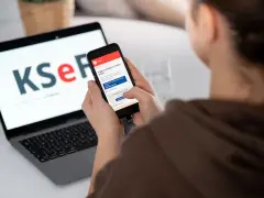Kobieta sprawdza na telefonie informacje o KSeF, co może być związane z tym, dlaczego od 2026 roku najemcy coraz częściej żądają faktur VAT za mieszkanie.