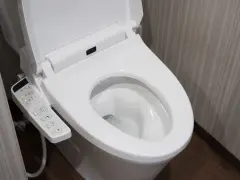 Panneau de commande d'une toilette japonaise. Il montre les options de nettoyage et de séchage, illustrant le fonctionnement de cet appareil moderne.
