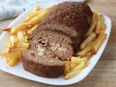 Polpettone ripieno di prosciutto e formaggio, cotto in friggitrice ad aria, servito con patatine fritte croccanti.