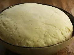 Puszyste ciasto na pizzę w misce, gotowe do pieczenia. Dowiedz się, jak rozmrozić ciasto na pizzę, by było idealne.