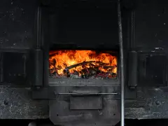 Piec kaflowy z płonącym drewnem. Czas na wymianę pieca na wsi?