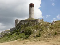 Ruiny zamku na wzgórzu, część Szlaku Orlich Gniazd. Charakterystyczna okrągła wieża i kamienne mury.