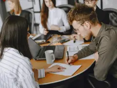 Uomini e donne in riunione, concentrati sul lavoro. Le 40 ore settimanali sono un impegno serio per raggiungere gli obiettivi.
