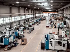 Hala produkcyjna z maszynami, gdzie trwa szybkie prototypowanie. Widać linie produkcyjne, magazyny i pracowników.