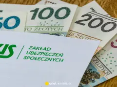Koperta ZUS z napisem "Zakład Ubezpieczeń Społecznych" na tle polskich banknotów 50, 100, 200 i 500 zł. Symbolizuje świadczenie kompensacyjne.